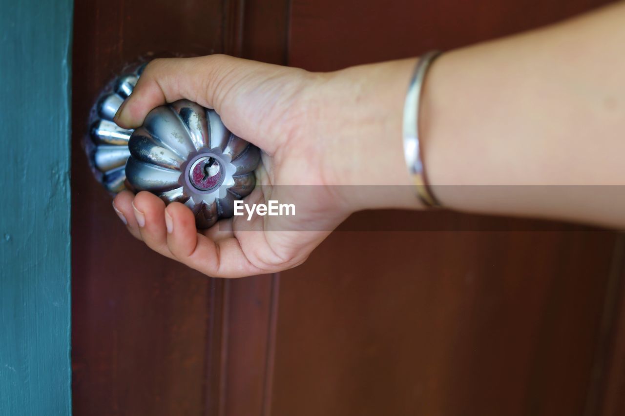 Cropped image of woman hand holding doorknob