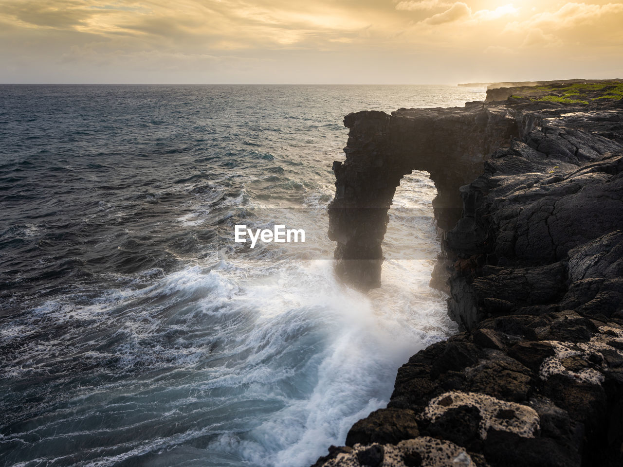 Scenic view of rocks in sea against sky