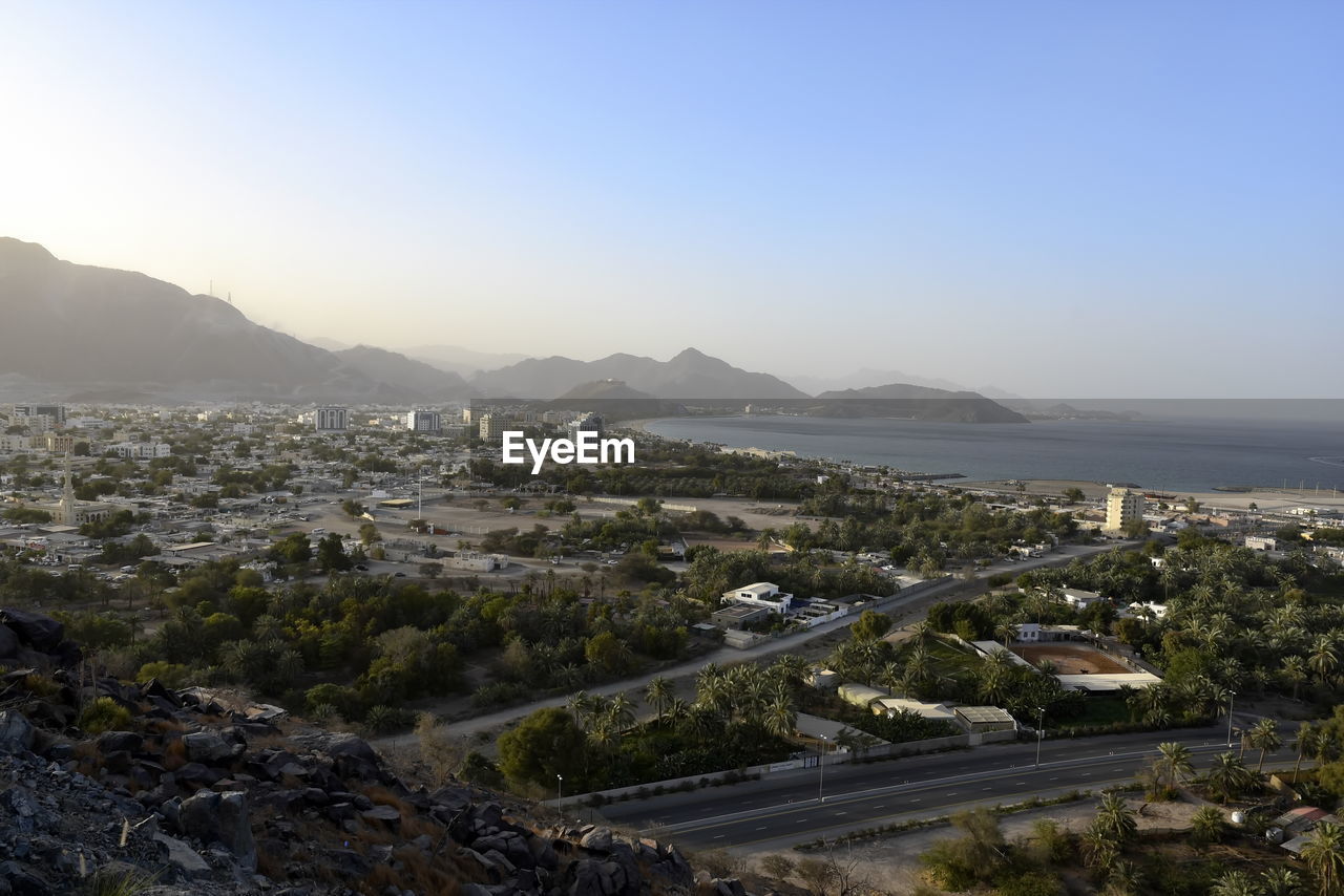 HIGH ANGLE VIEW OF TOWNSCAPE AND MOUNTAINS AGAINST SKY