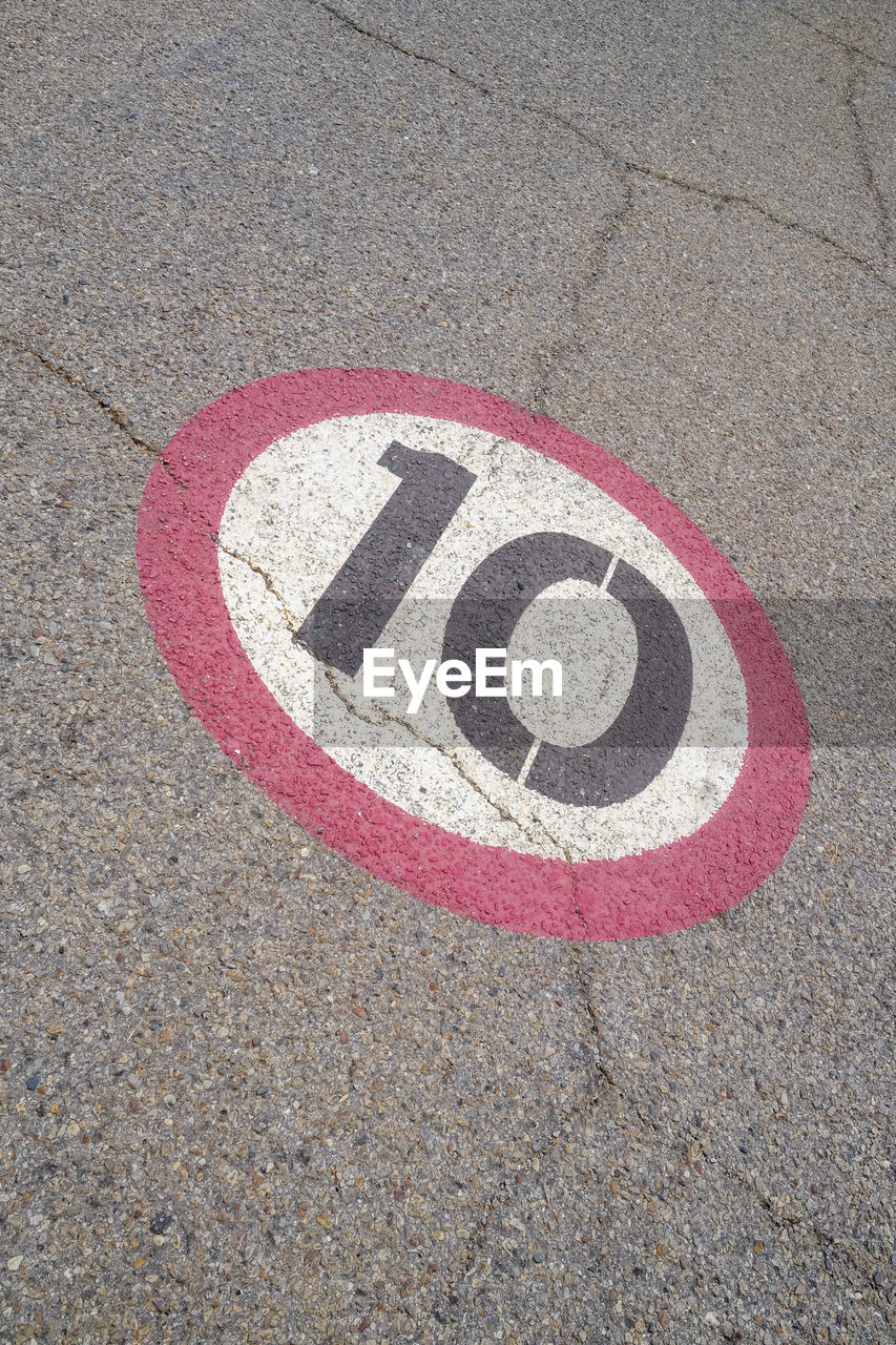 circle, road, sign, high angle view, communication, no people, geometric shape, transportation, day, street, flooring, road surface, city, number, red, asphalt, shape, symbol, road sign, pink, guidance, sand, outdoors, close-up