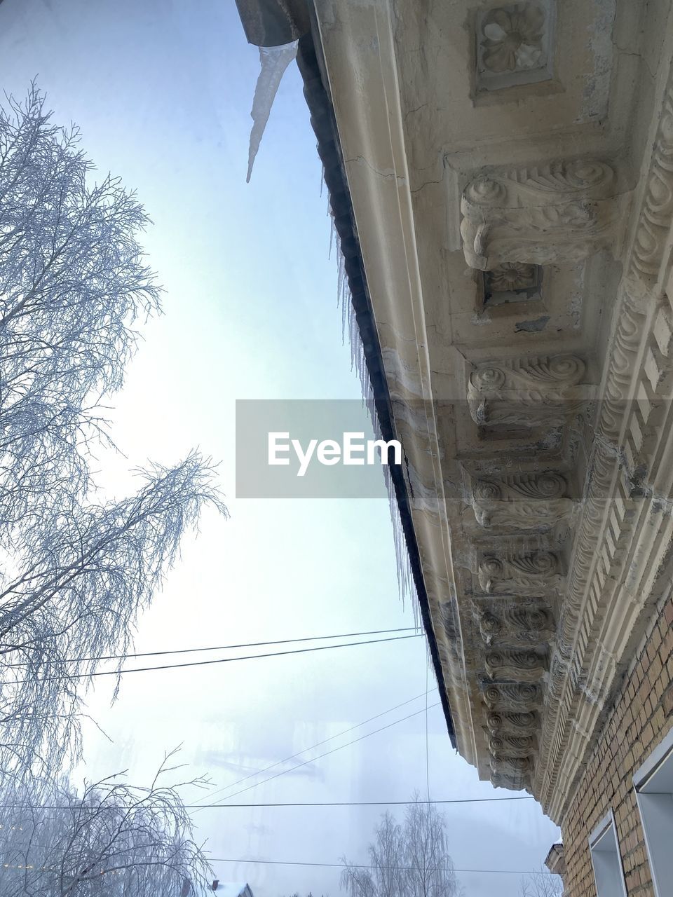 LOW ANGLE VIEW OF FROZEN BUILDING AGAINST SKY