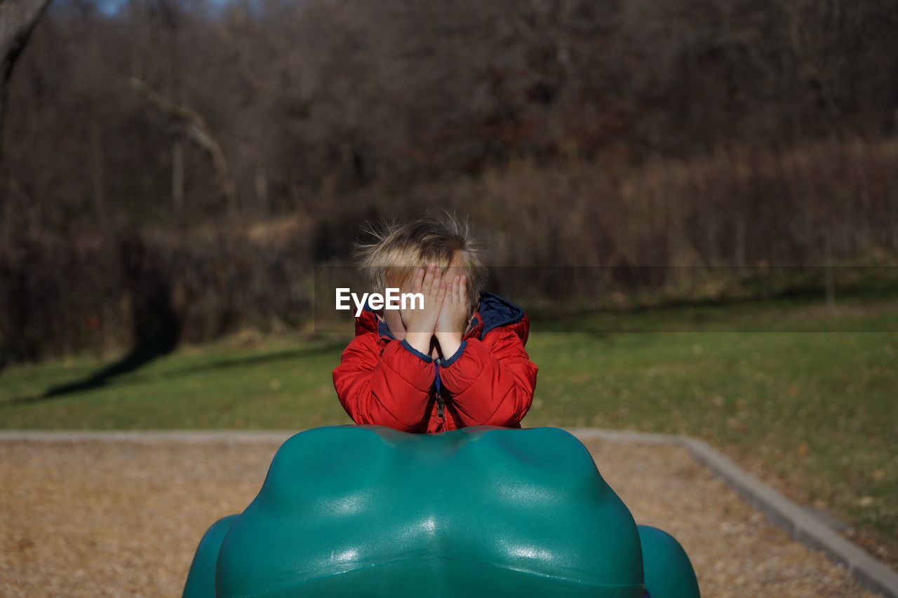 Boy hiding face at playground