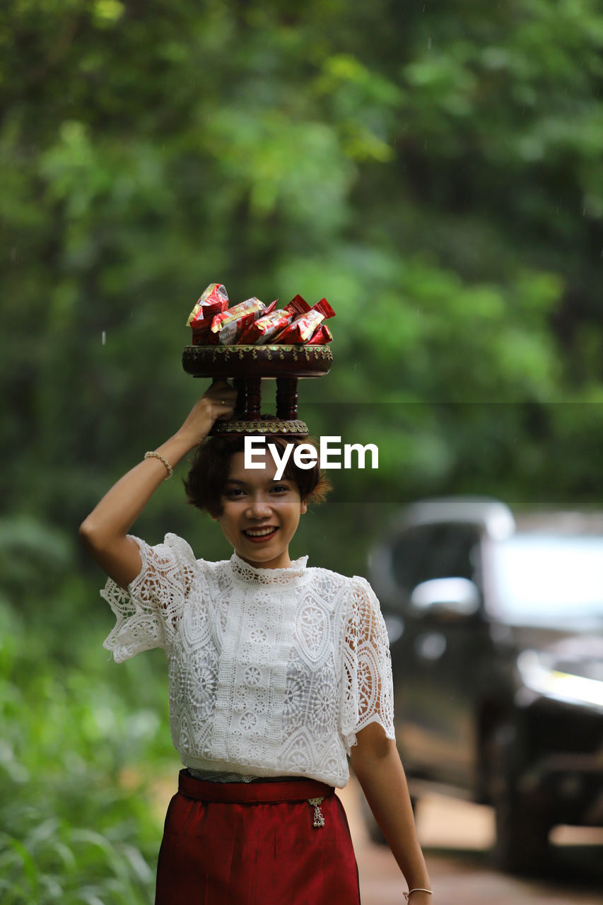 Portrait of a smiling young woman holding plant