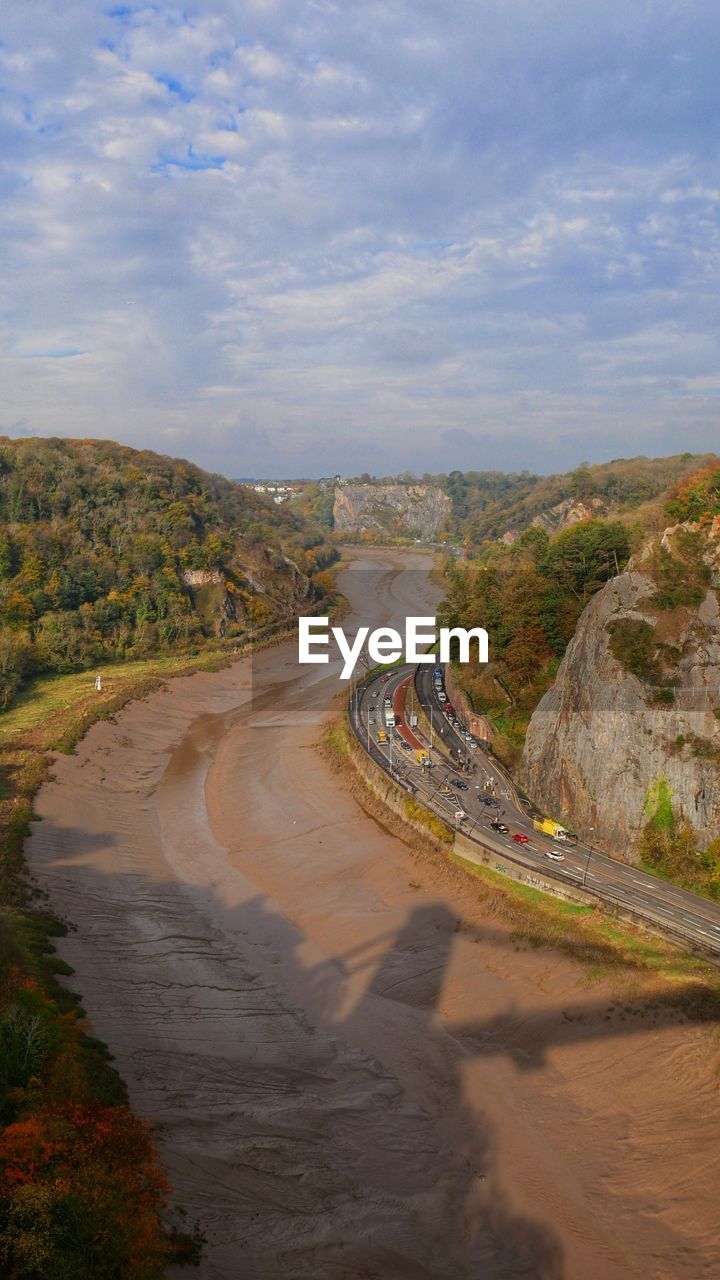 HIGH ANGLE VIEW OF ROAD BY LAND AGAINST SKY