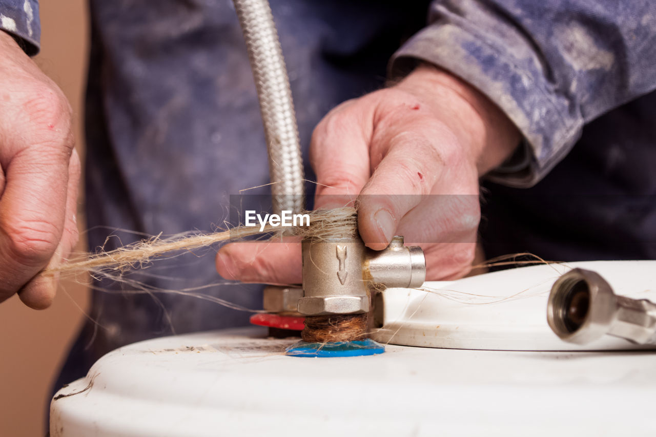 Flat renovation, plumber, puts hemp thread around the valve