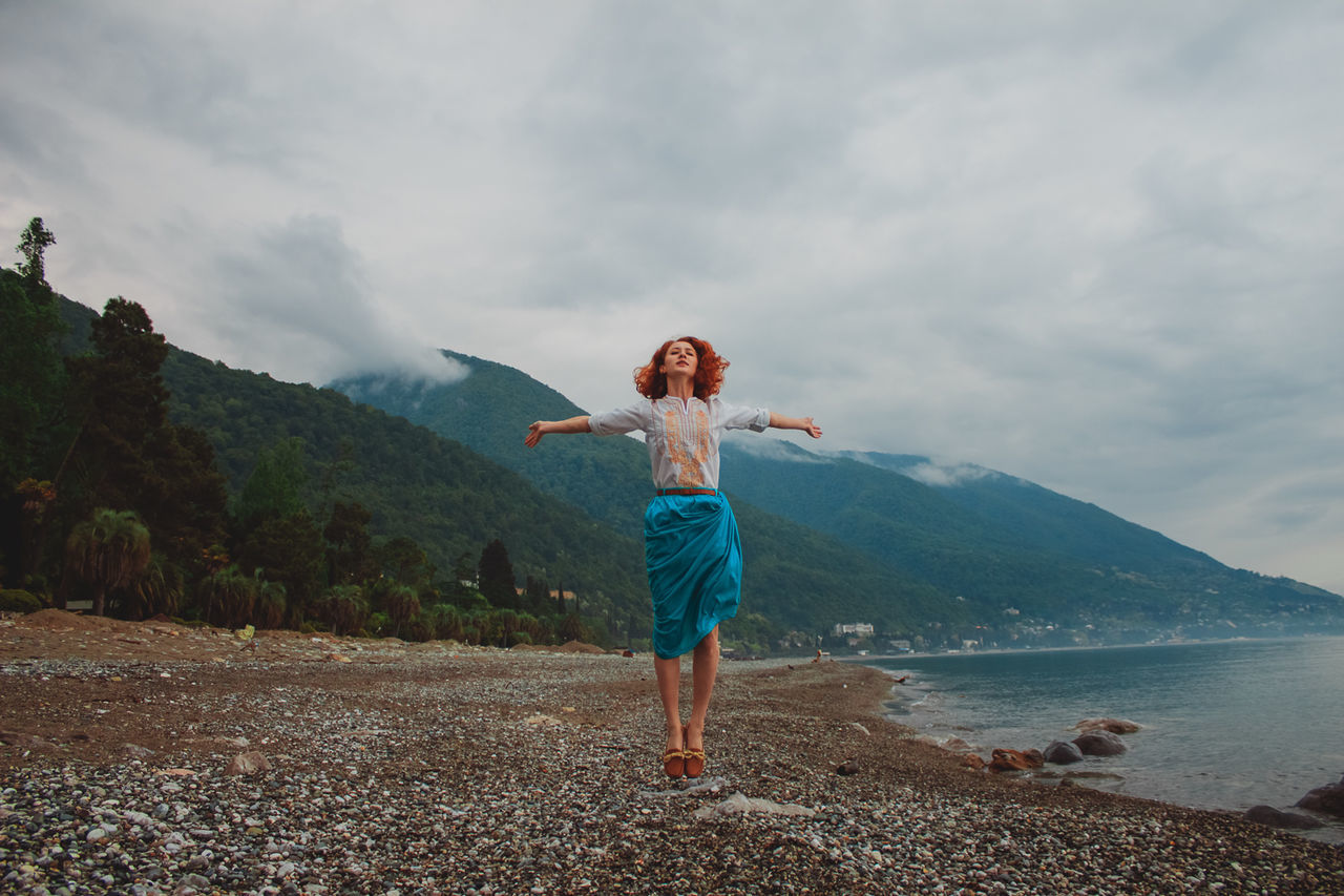 Full length of woman jumping on shore