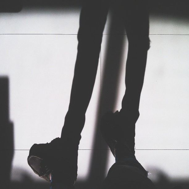 LOW SECTION OF WOMAN STANDING ON TILED FLOOR