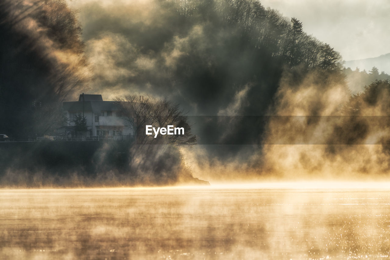 scenic view of lake against cloudy sky during sunset