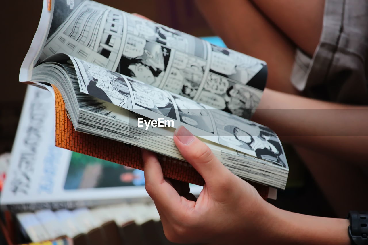 MIDSECTION OF WOMAN HOLDING PAPER