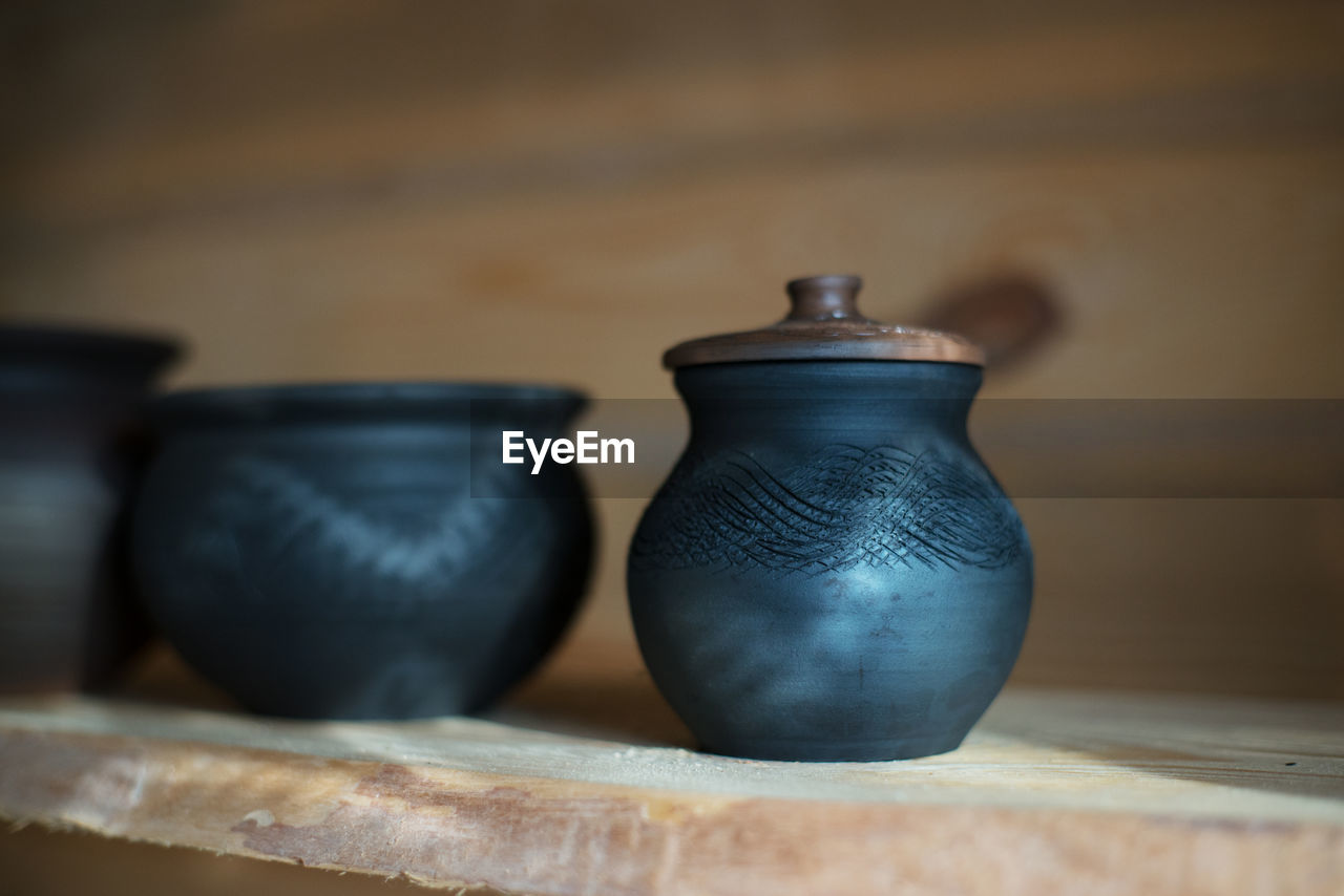 Close-up of pots on shelf at workshop