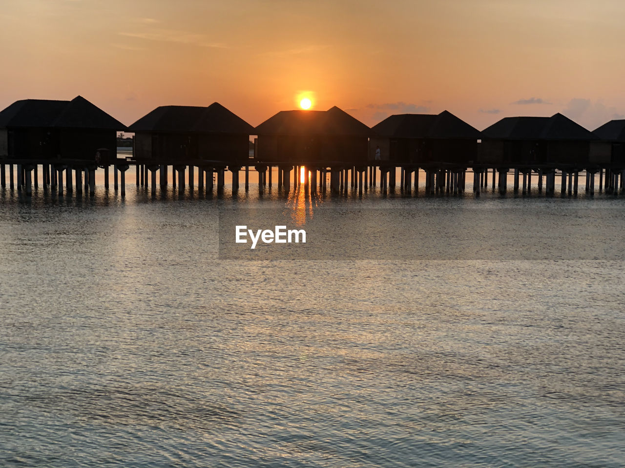 Maldives island sunset. water bungalows resort at islands beach