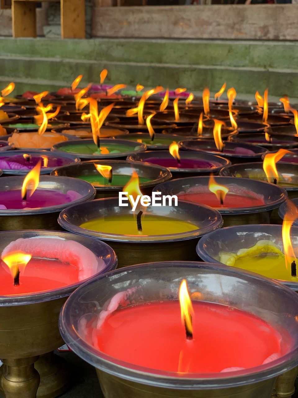 Close-up of lit tea light candles in building