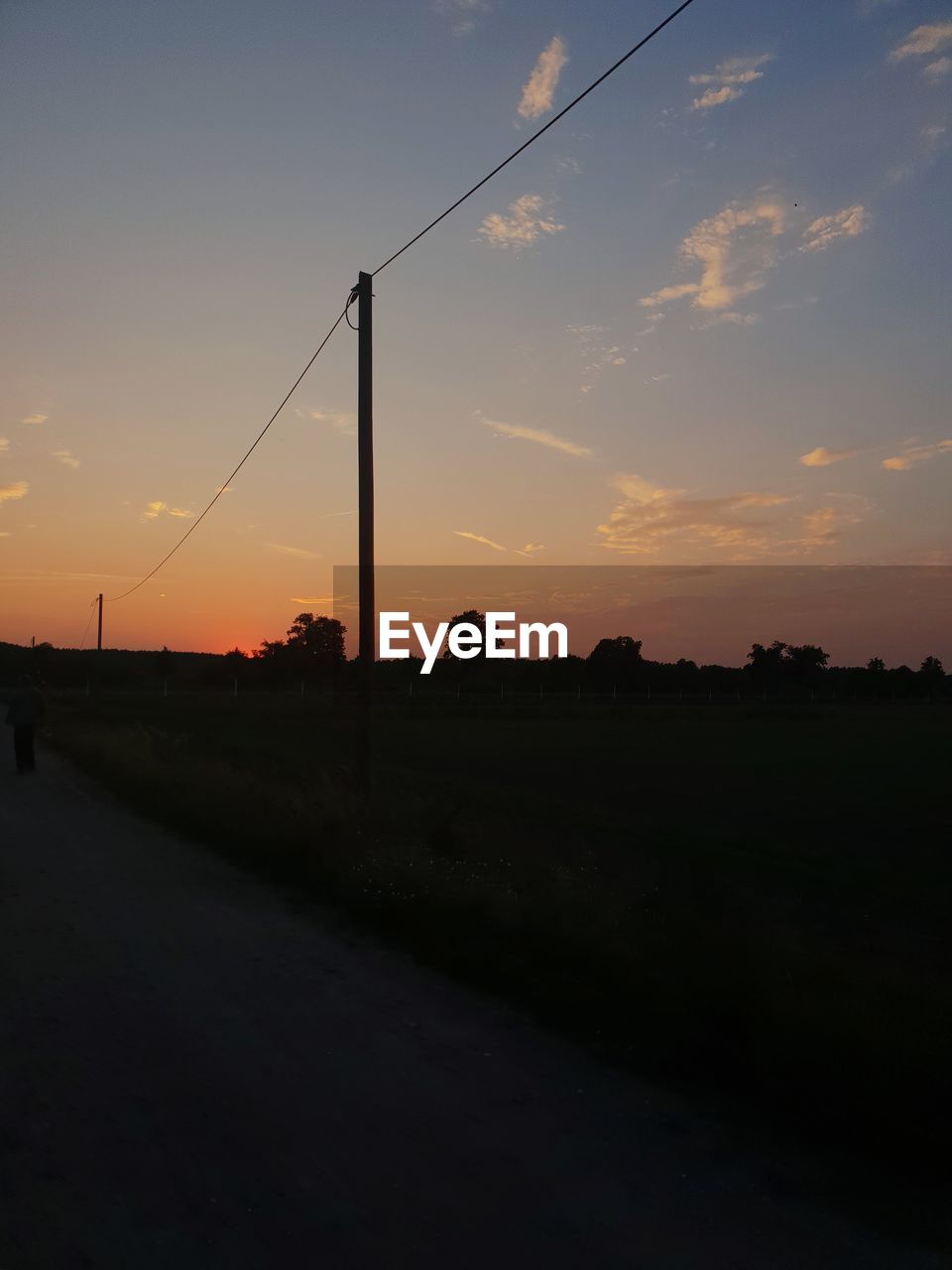 Scenic view of silhouette field against sky at sunset