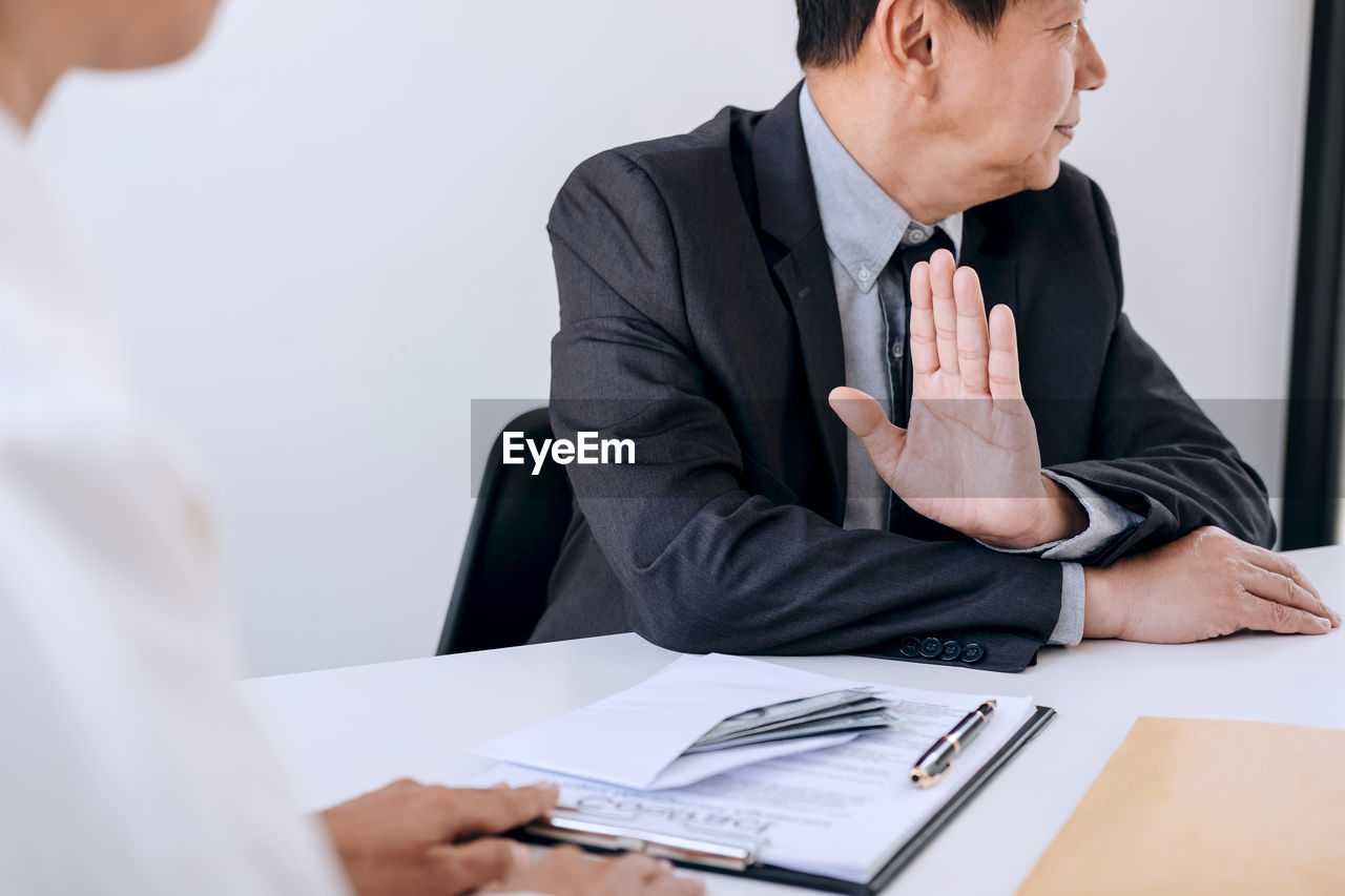 Businessman gesturing colleague in office