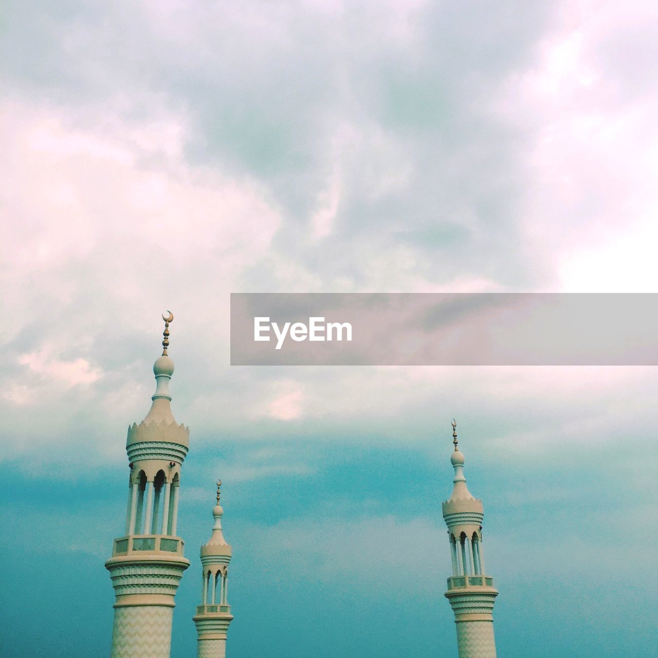 Low angle view of masjid sheikh zayed mosque minarets against cloudy sky