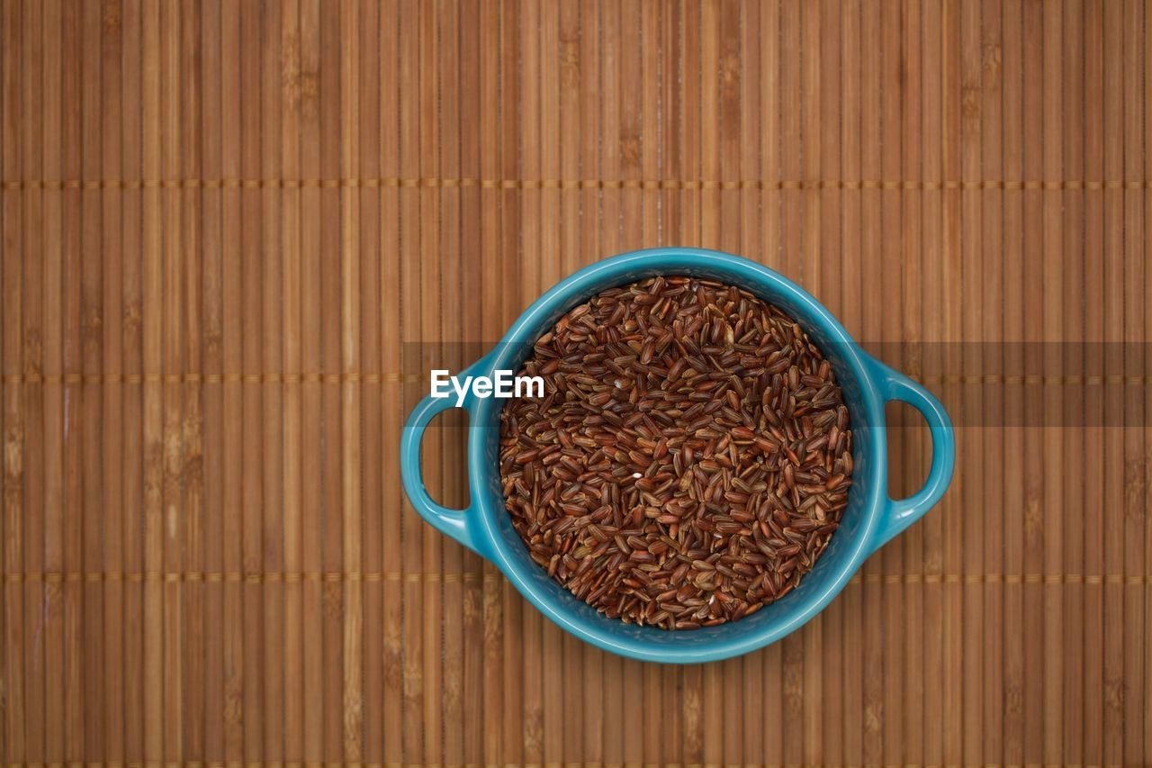 Directly above view of wheat in bowl bamboo mat