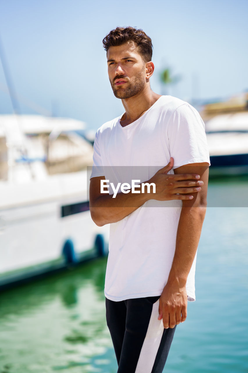 Young man standing at harbor