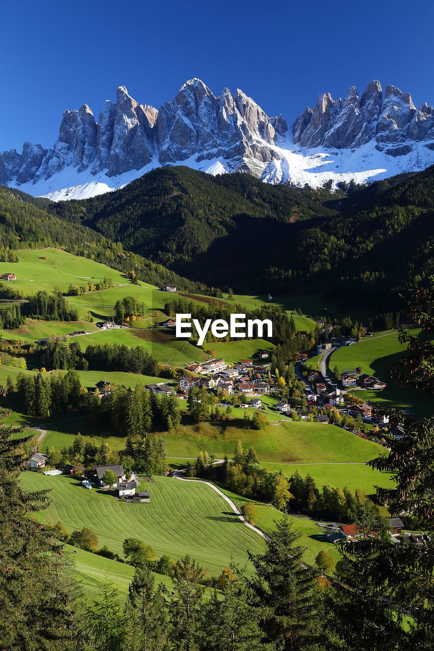 Scenic view of green landscape and mountains against clear sky