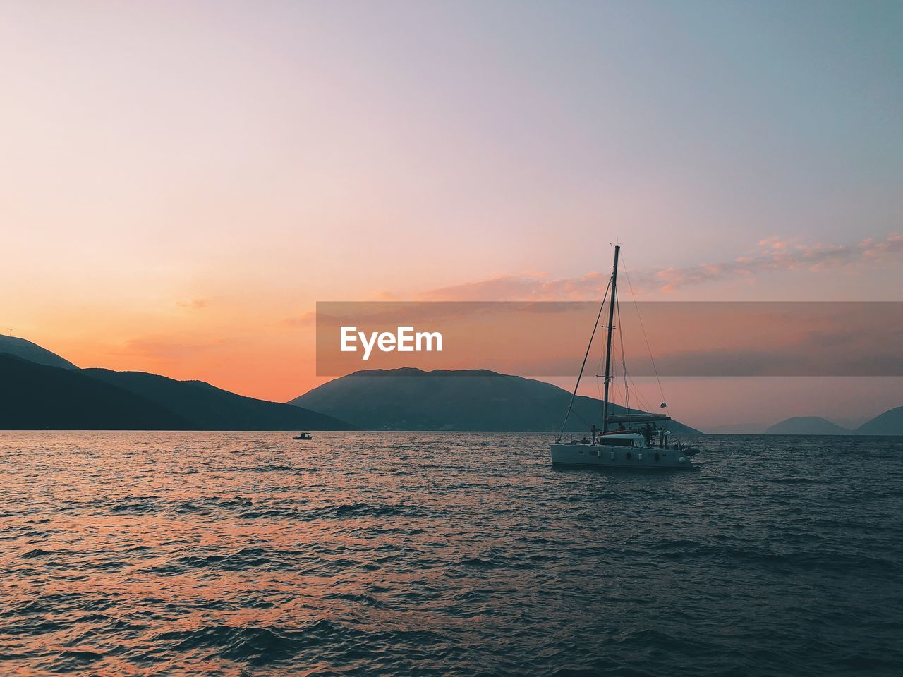 Sailboat on sea against sky during sunset