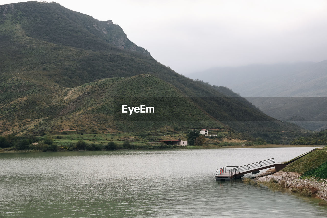 water, mountain, lake, reservoir, environment, scenics - nature, nature, landscape, beauty in nature, land, no people, sky, highland, architecture, tranquility, transportation, nautical vessel, travel, body of water, mountain range, travel destinations, plant, bay, tranquil scene, tourism, tree, outdoors, fog, built structure, beach, day, non-urban scene, building, forest, coast, rural scene, cloud, idyllic, overcast, house, holiday, vacation, building exterior, trip, village