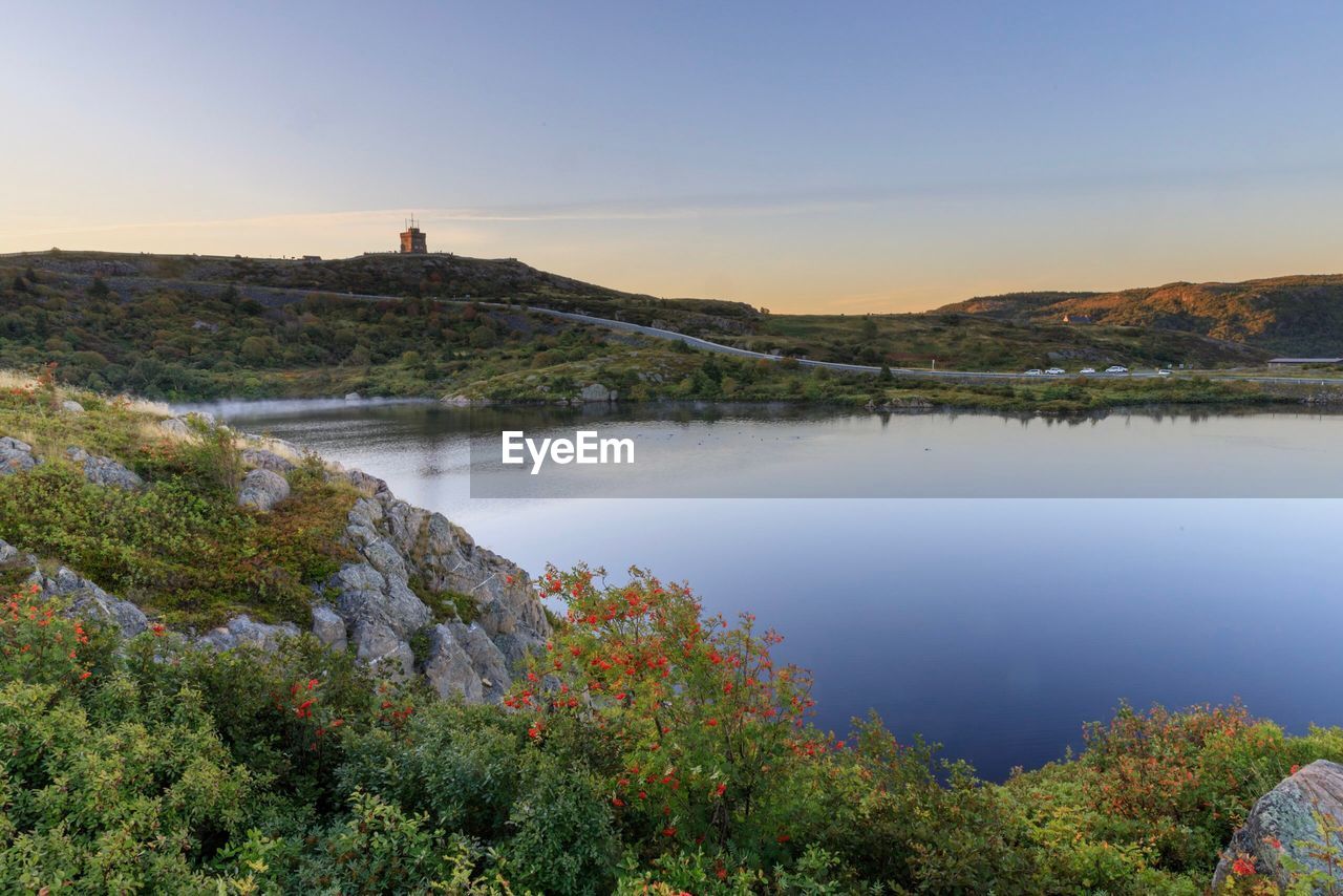 Scenic view of lake and mountains against clear sky