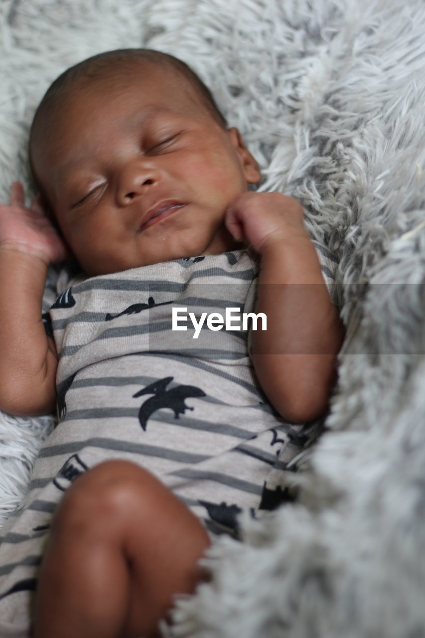 High angle view of baby sleeping on bed