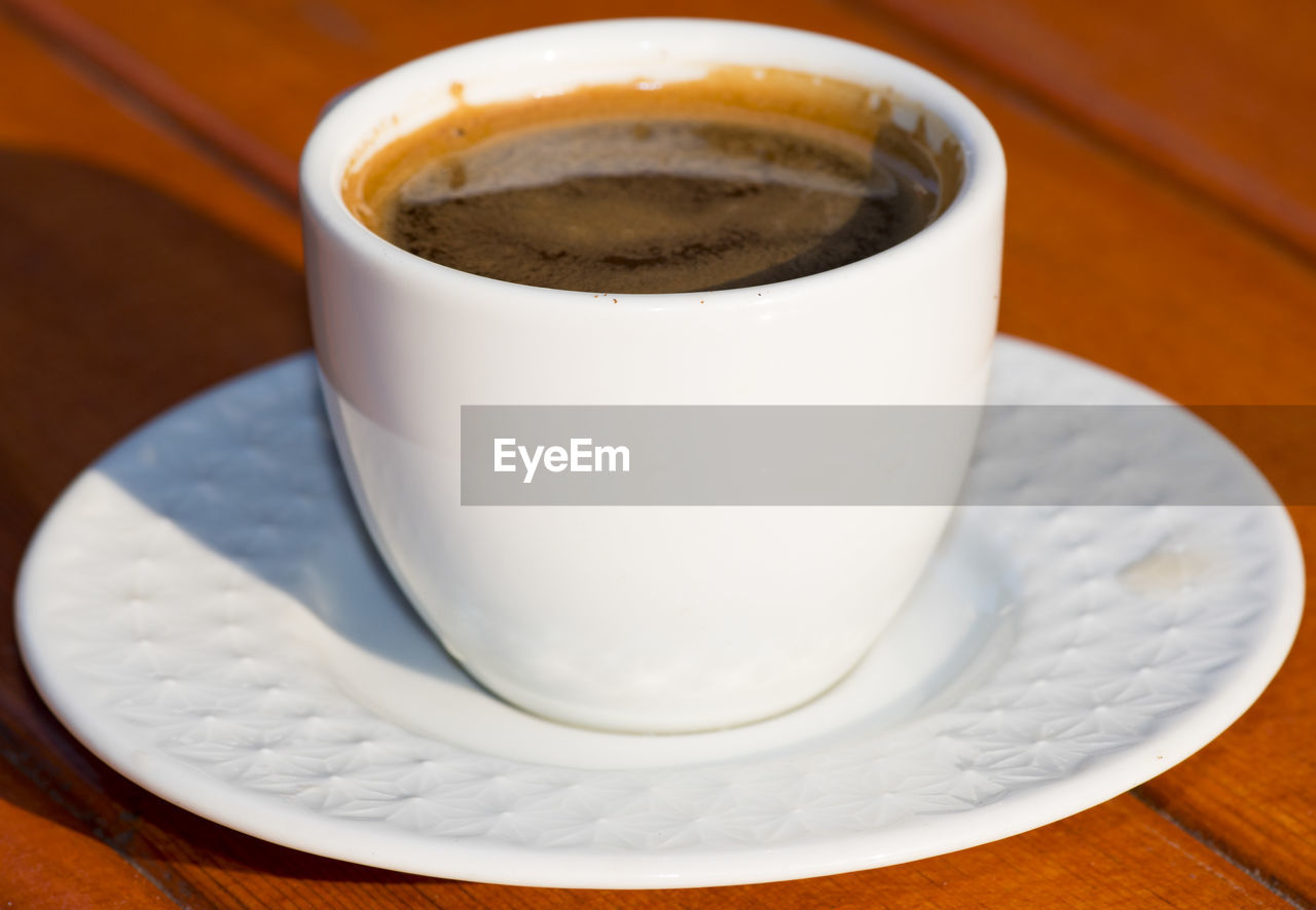 CLOSE-UP OF CUP OF COFFEE ON TABLE