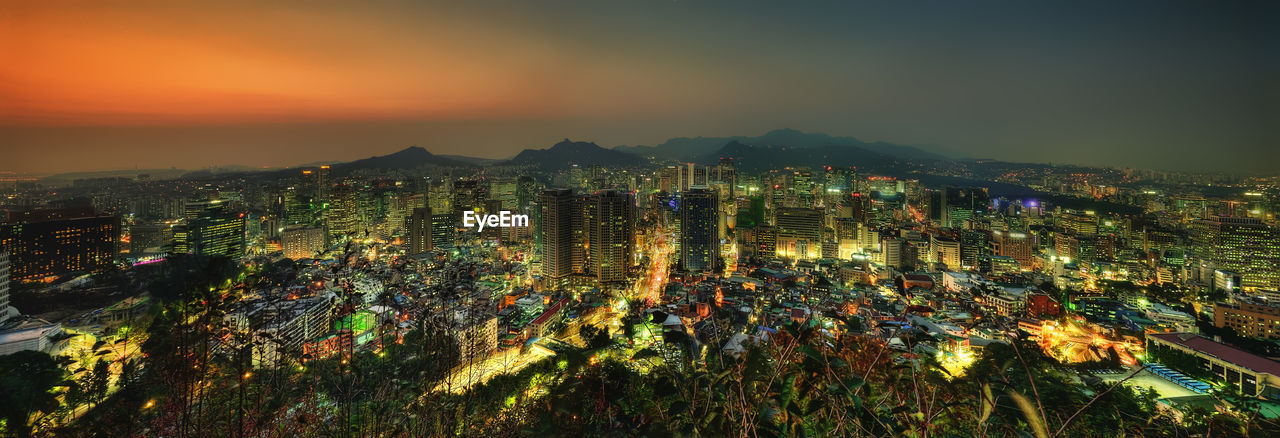 High angle view of illuminated buildings against sky at night