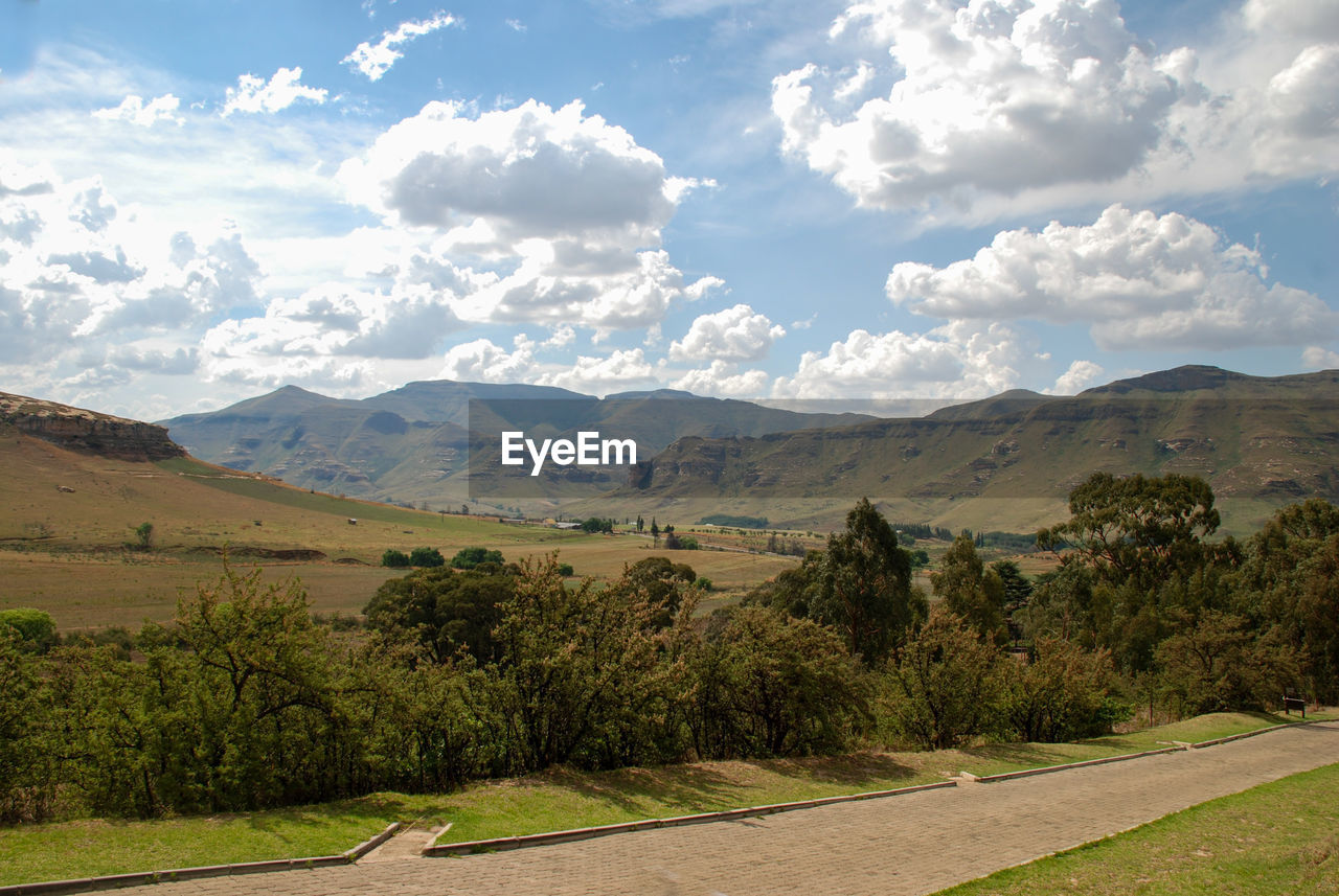 SCENIC VIEW OF ROAD AMIDST FIELD AGAINST SKY