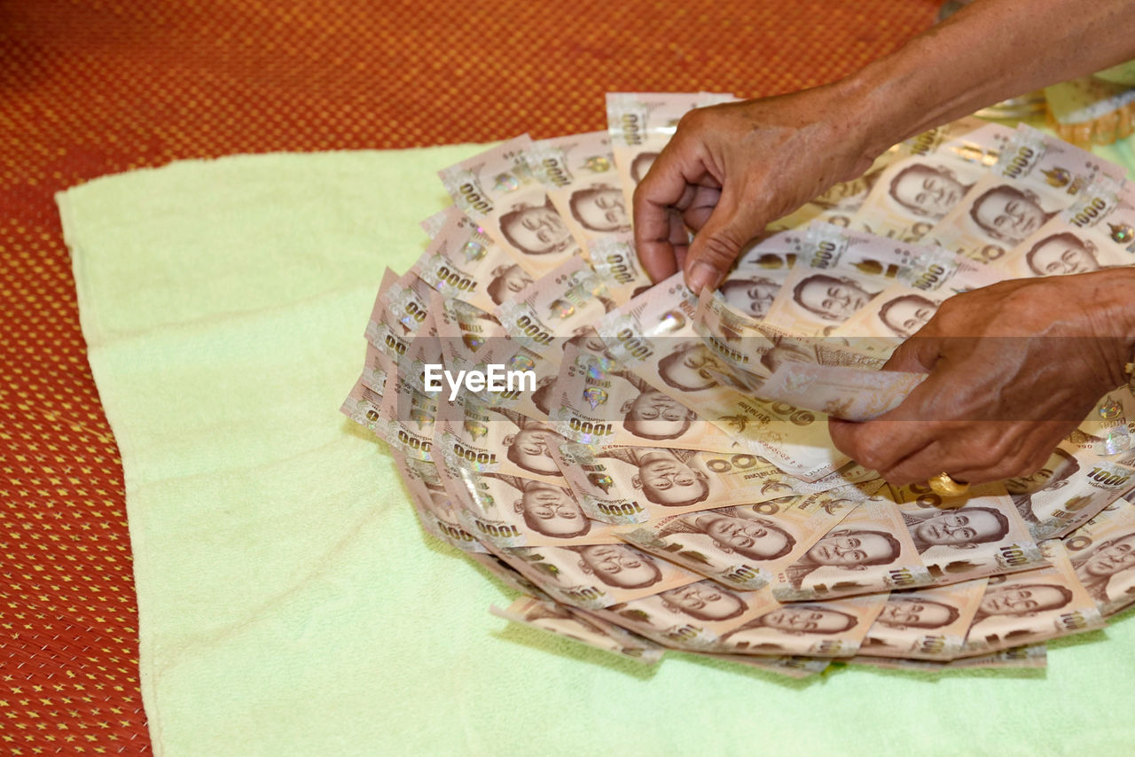 Close-up of man arranging paper currency