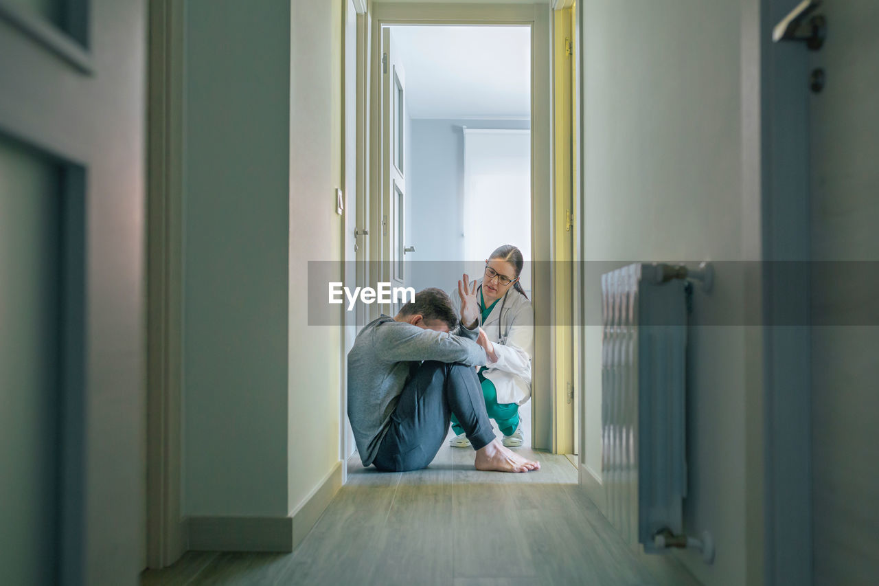 Female doctor trying to help male patient with mental disorder