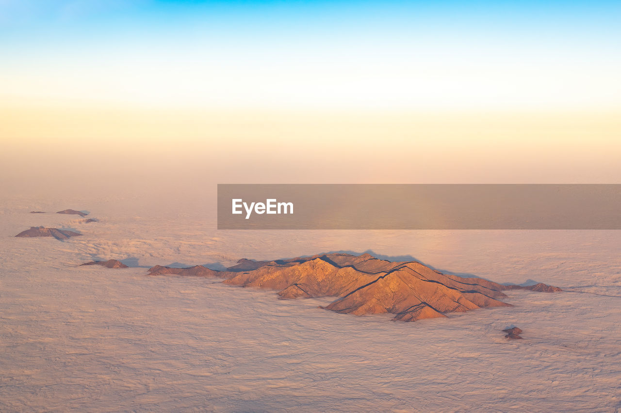 Aerial view of the top of a mountain rising above the clouds