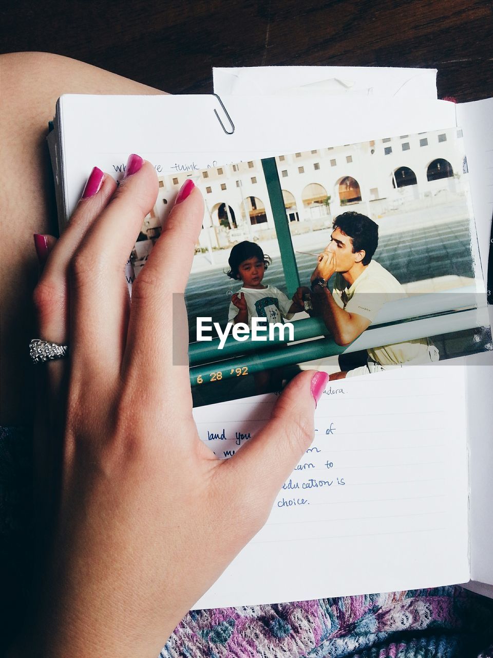 Cropped image of woman touching photograph