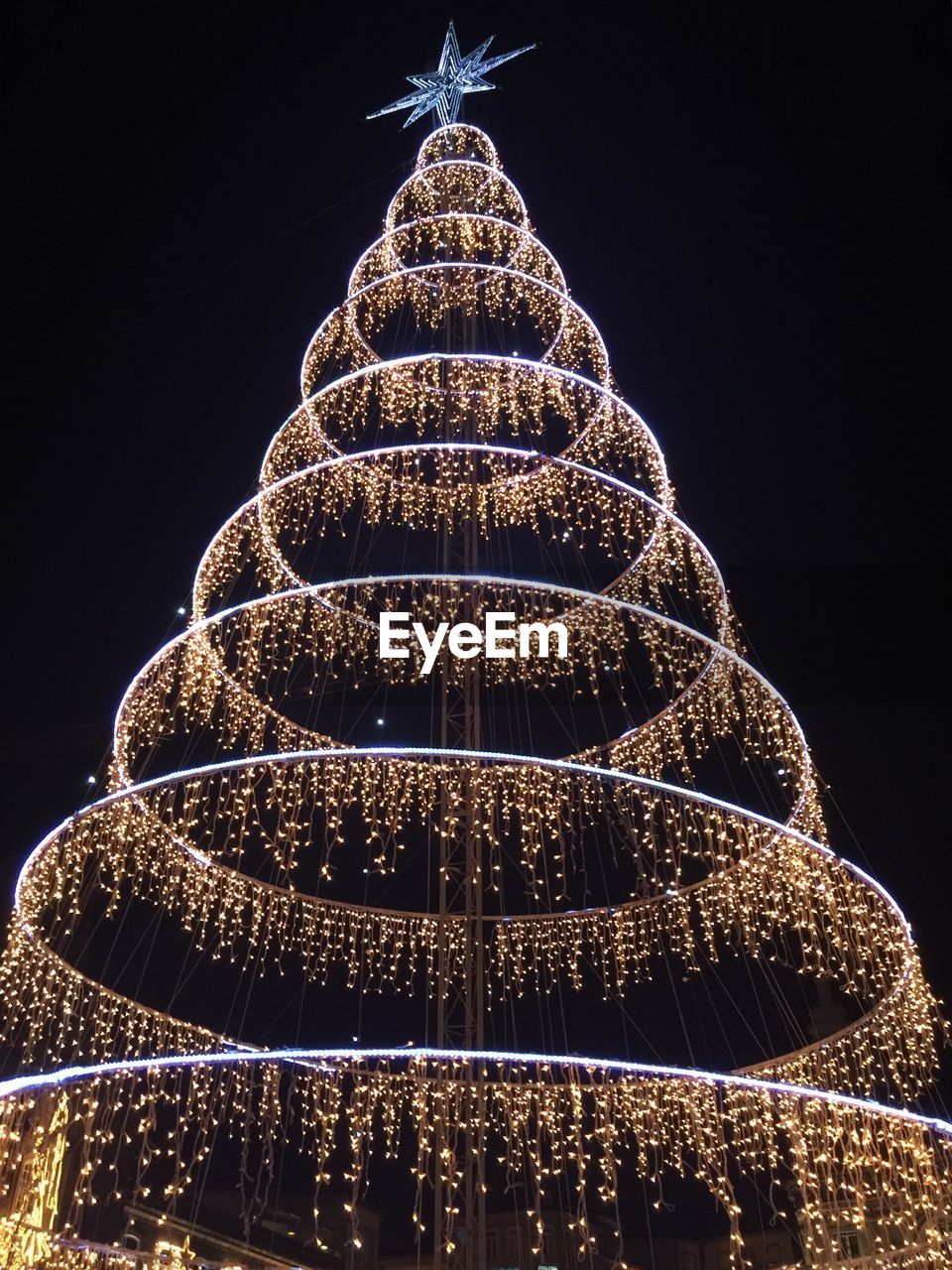 Low angle view of illuminated decorative structure against sky at night during christmas