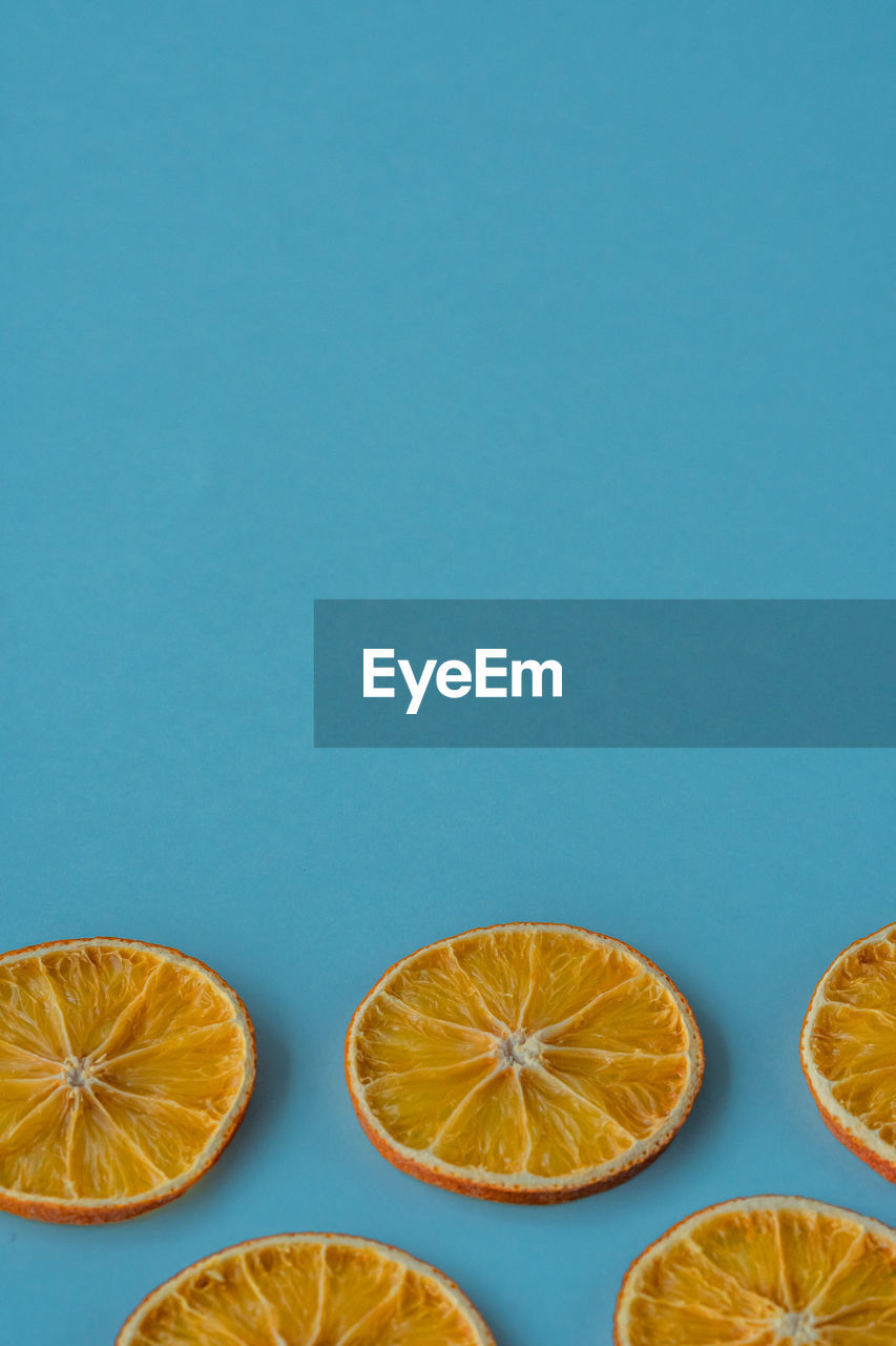 Flat layout of a dried orange fruit slices on a blue background