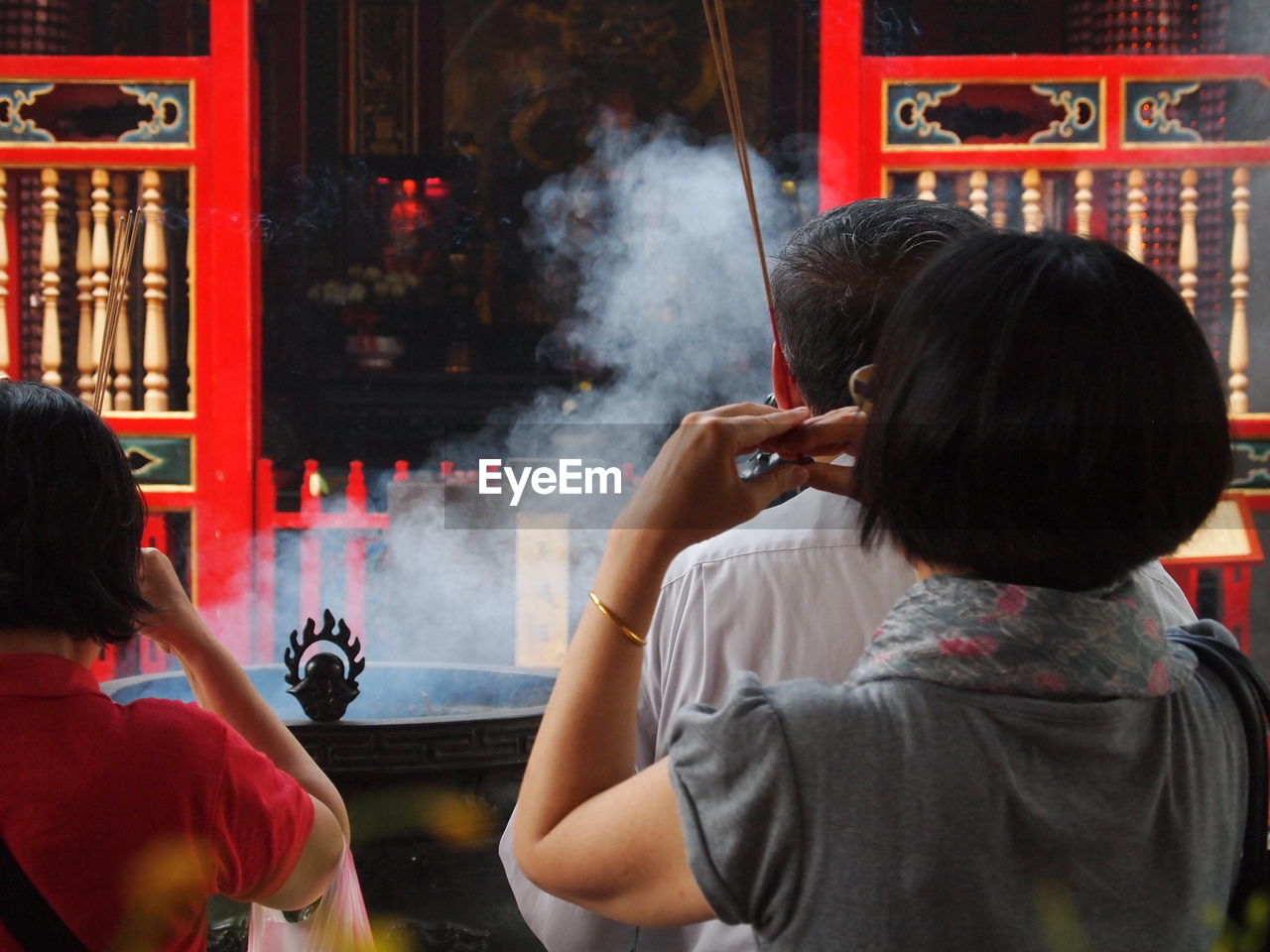 Rear view of people praying at buddhist temple