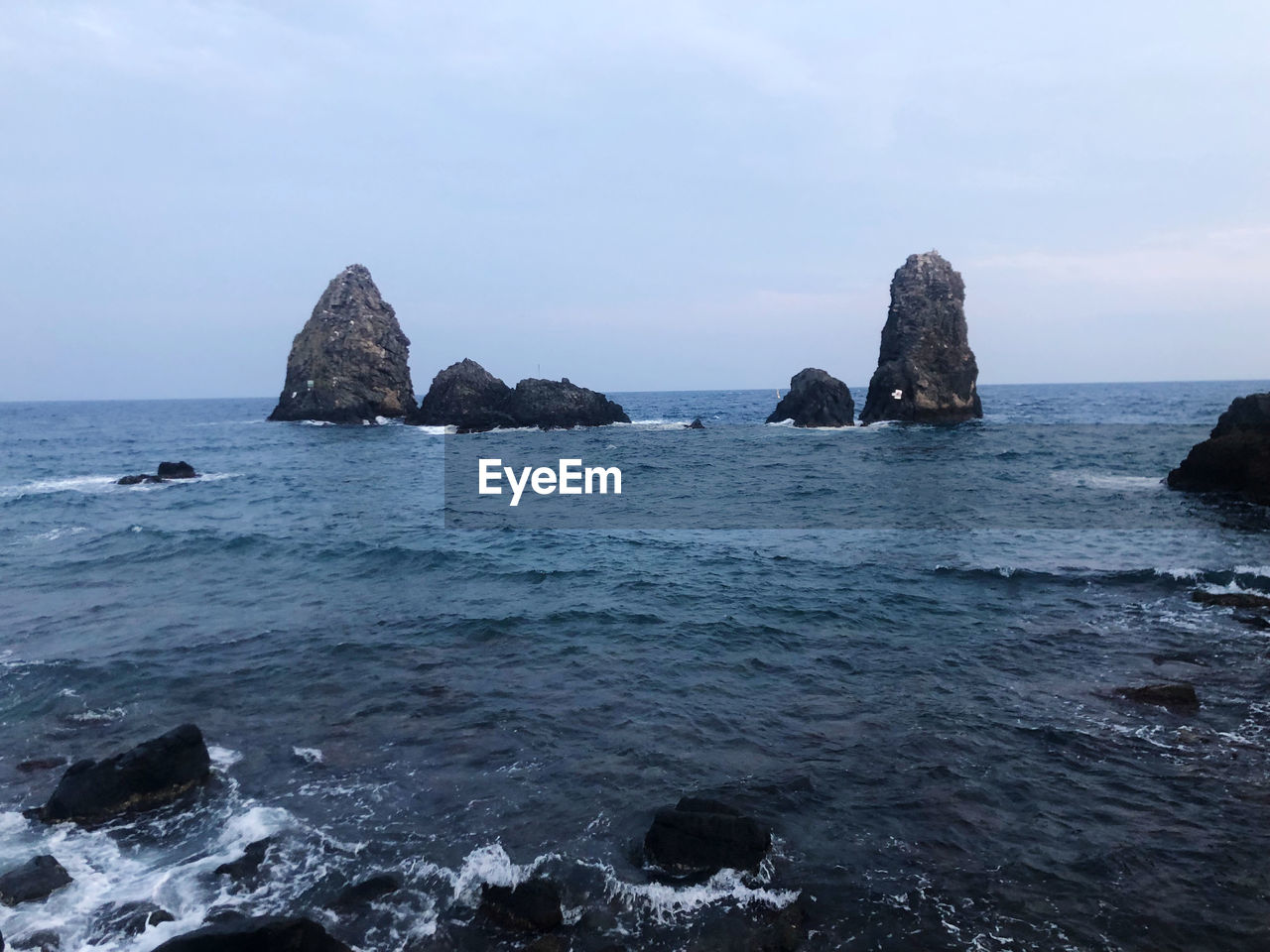 ROCKS ON SEA AGAINST SKY