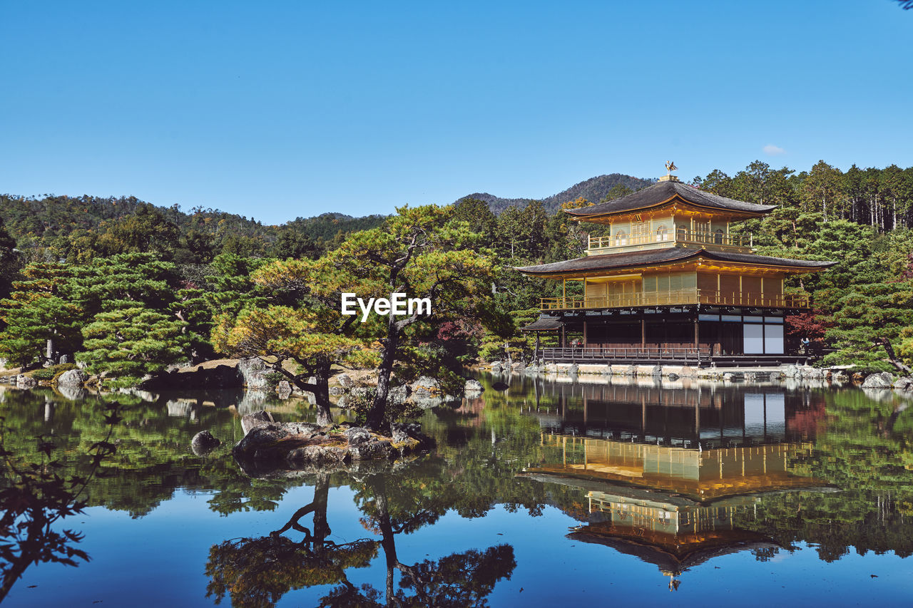 Reflection of trees and kinkaku-ji temple on lake