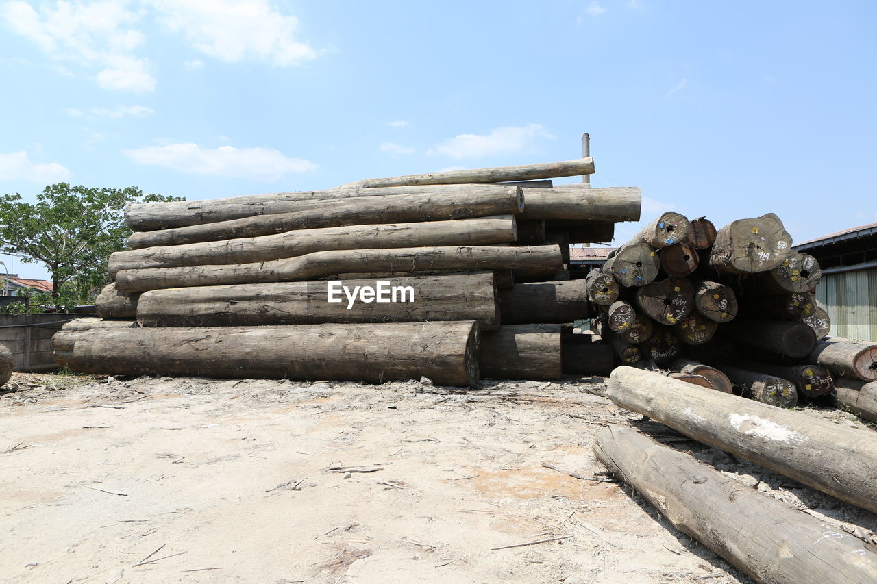 STACK OF FIREWOOD AGAINST SKY