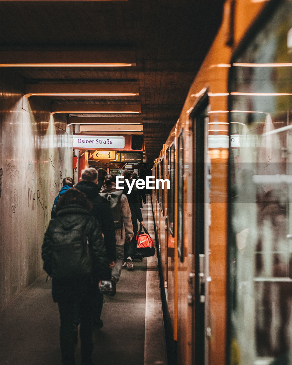 PEOPLE WALKING AT RAILROAD STATION PLATFORM