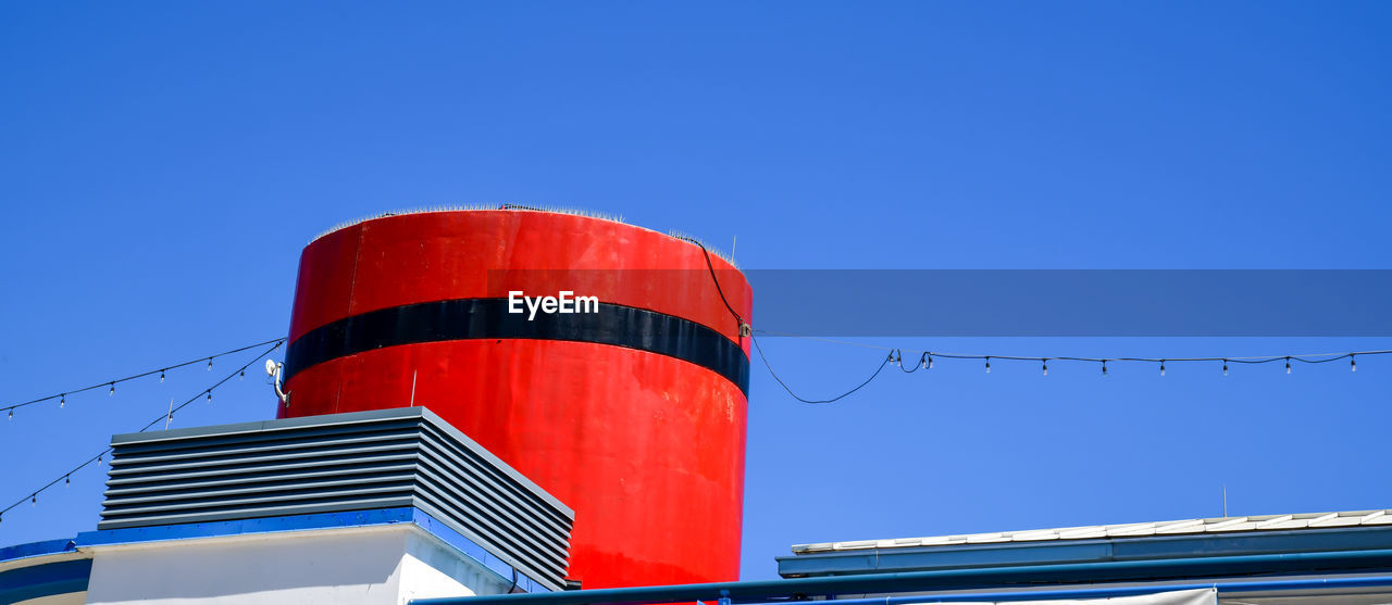 Vintage red steam ship smoke stack and blue sky