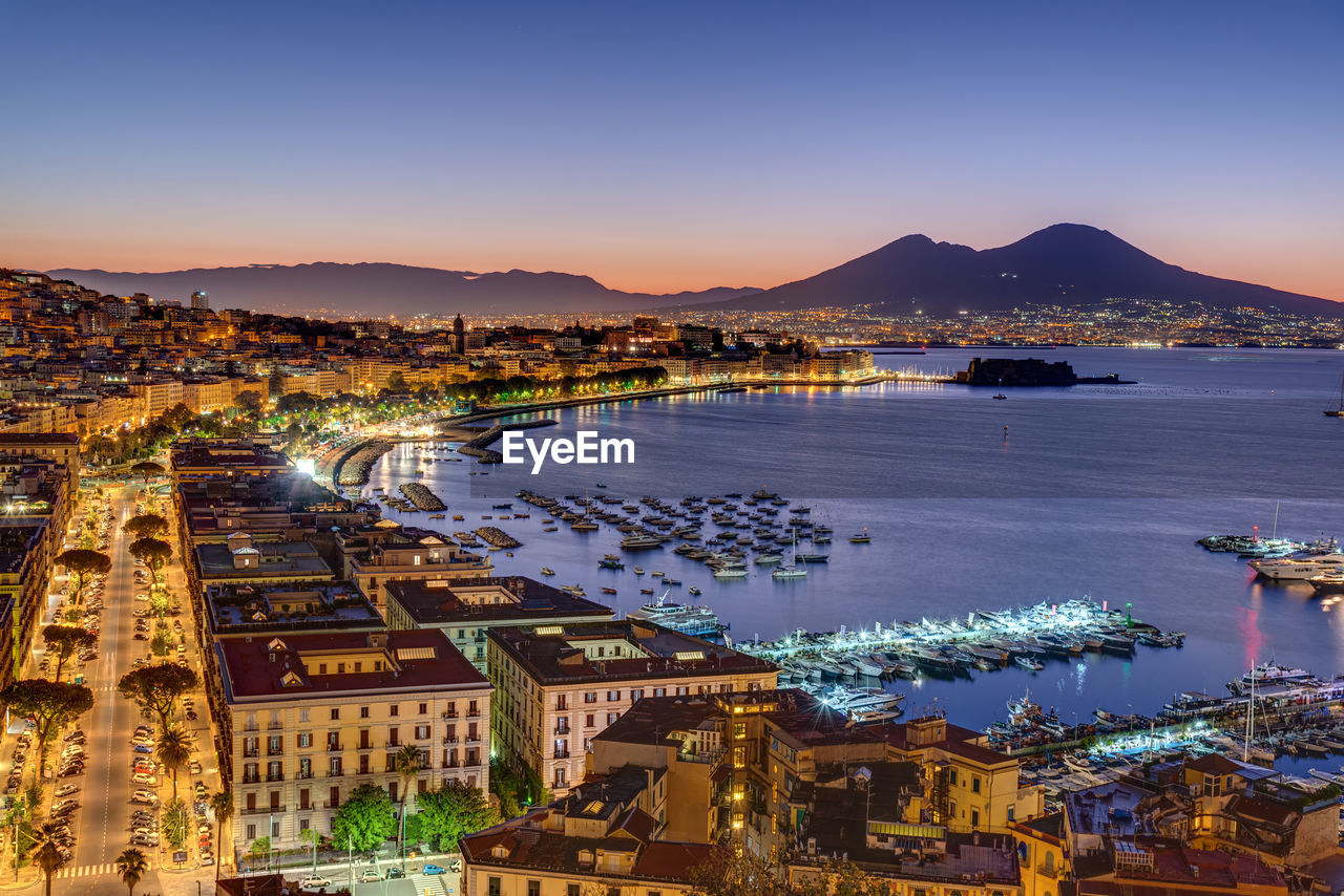 Aerial view of townscape by sea against sky