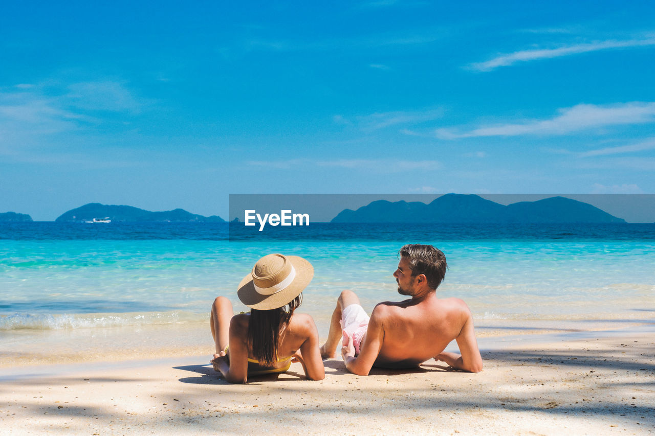 rear view of woman sitting at beach