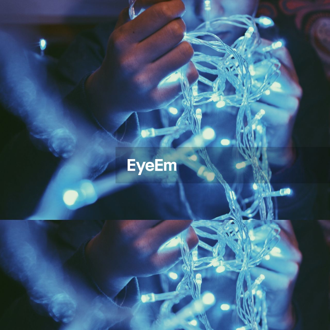 Close-up of hands holding fairy lights