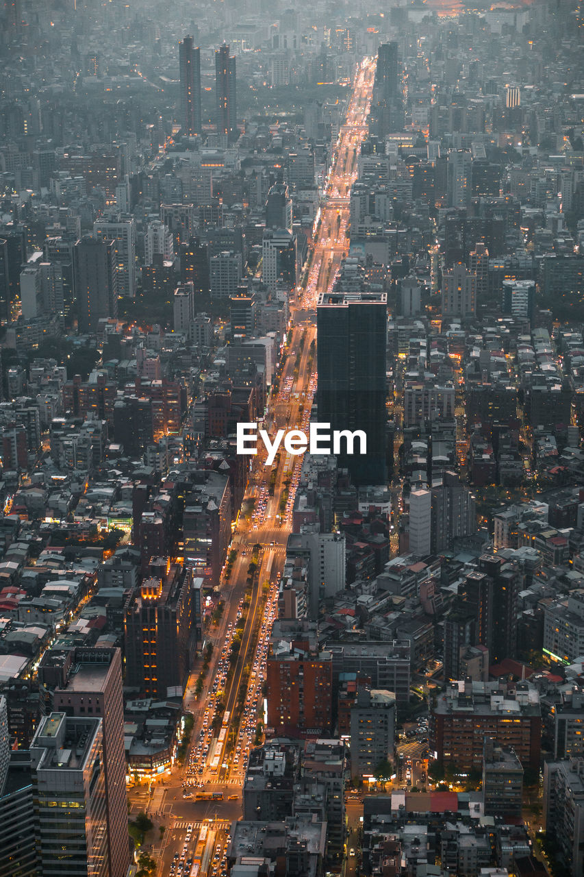 Aerial view of illuminated city street amidst buildings