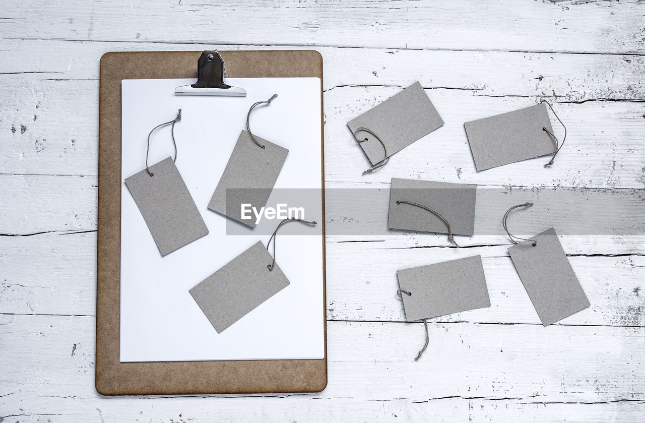 High angle view of price tags by clipboard on table