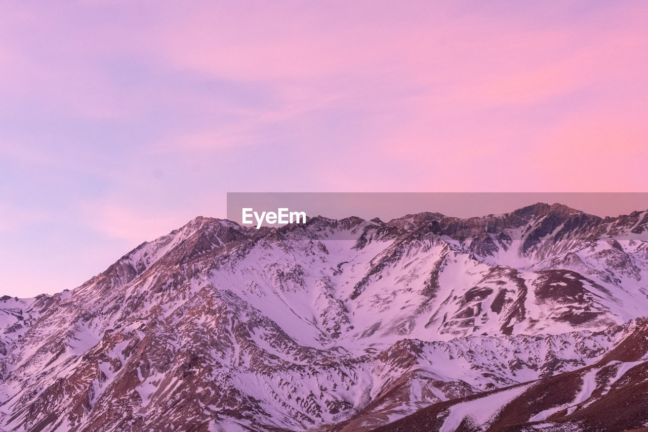 Scenic view of snowcapped mountains against pink sky during sunset