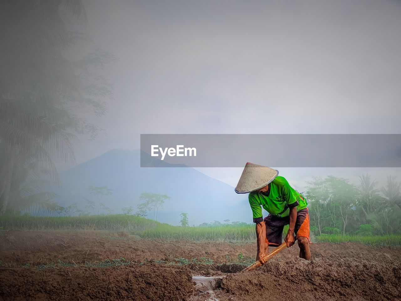 Man working on agricultural field against sky