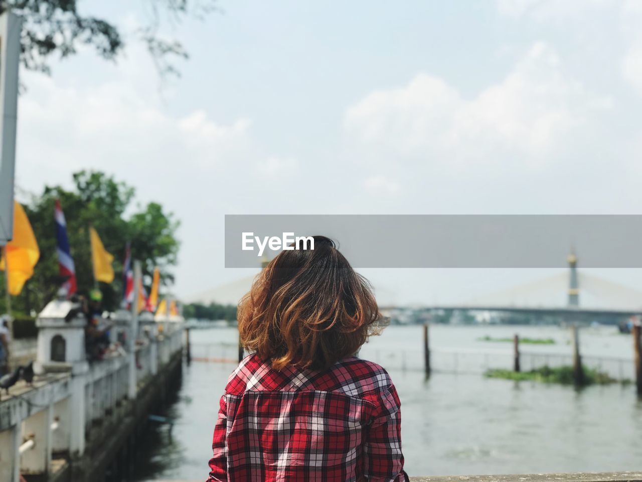 Rear view of woman standing at riverbank