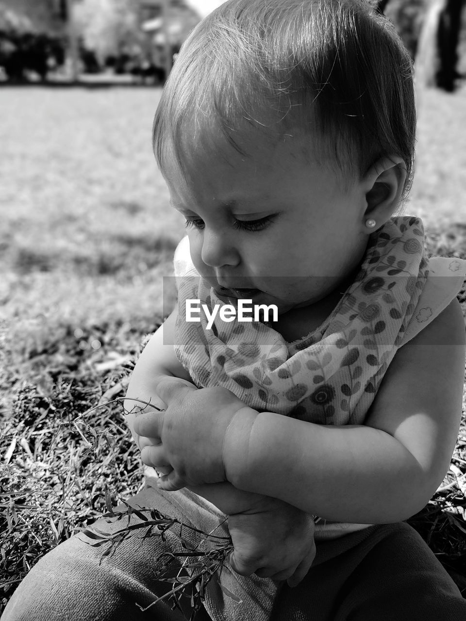 Cute baby girl sitting on field